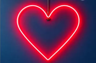 plakat na którym na ciemnym tle widoczny jest tylko duży zaświecony czerwony neon w kształcie serca