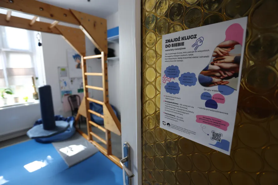 Plakat informacyjny o terapii i wsparciu, z elementami wyposażenia sali terapeutycznej.