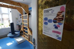 Plakat informacyjny o terapii i wsparciu, z elementami wyposażenia sali terapeutycznej.