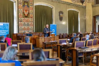 Zdjęcie przedstawia P F Prezydenta Krakowa- Stanisława Kracika, przemawiającego do nauczycieli w sali obrad rady miasta