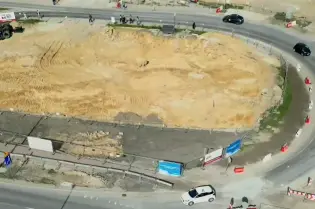 Pusty plac budowy z wytyczonymi drogami i znakami drogowymi.