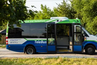 Autobus TeleBus z otwartymi drzwiami, zielono-niebieska kolorystyka, dostępny dla osób z niepełnosprawnościami.