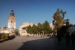 Krakowski rynek z wieżą ratuszową i budynkami w słoneczny dzień.