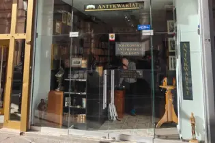 Antykwariat z witryną, w której znajdują się książki i różne przedmioty.
