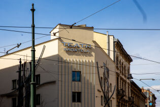 Fasada budynku Teatru Bagatela, Widać napis, elewację i bezchmurne niebo. Jest słoneczny dzień.