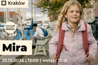 Kobieta z blond włosami spacerująca po ulicy w Krakowie, obok rowerów i budynków.