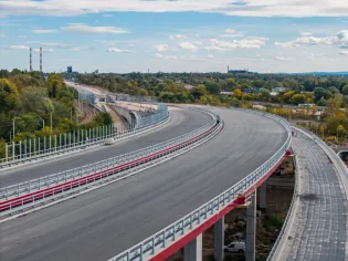 Nowa droga z widokiem na miasto i przemysłowe tereny w tle.