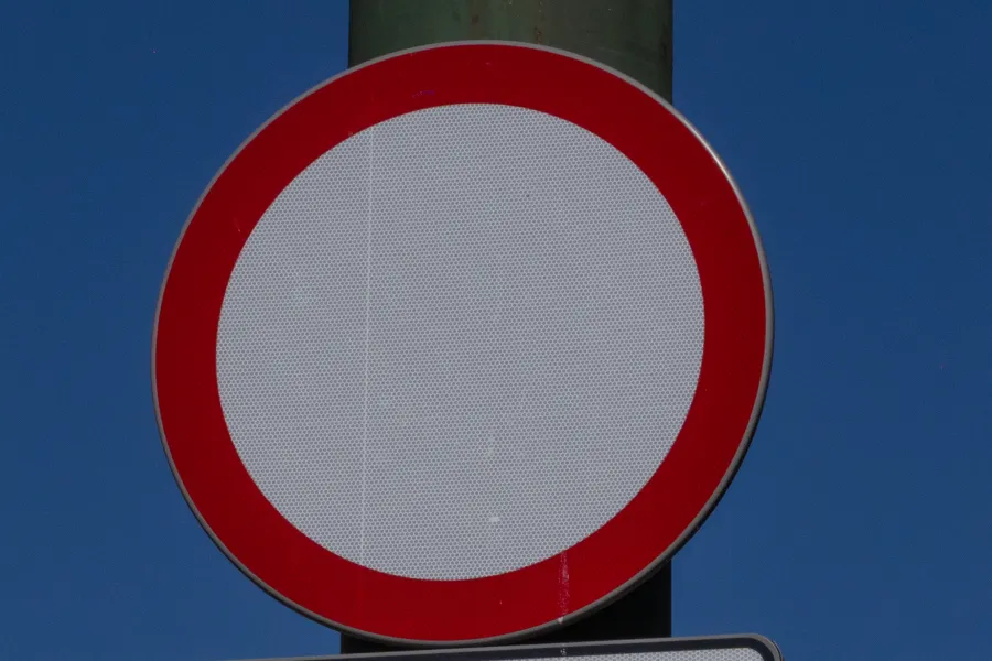 Pusty znak drogowy z czerwoną obwódką.