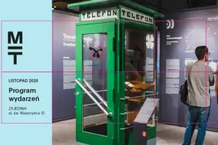 Stara budka telefoniczna w muzeum, obok niej zwiedzający oglądają wystawę.